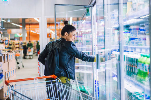 Young woman shopping in the supermarket Young woman shopping in the supermarket refrigerated section supermarket photos stock pictures, royalty-free photos & images