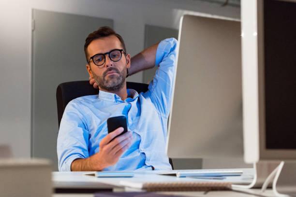 istock Mature businessman using smart phone at office 1131360248