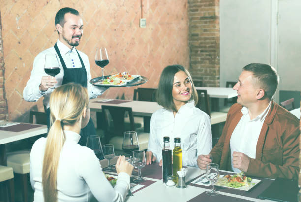 istock Young male waiter carrying order for visitors 1131360319