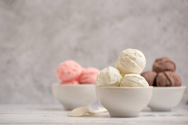 Bowl of vanilla, chocolate and pink berries ice cream on light background. Side view stock photo