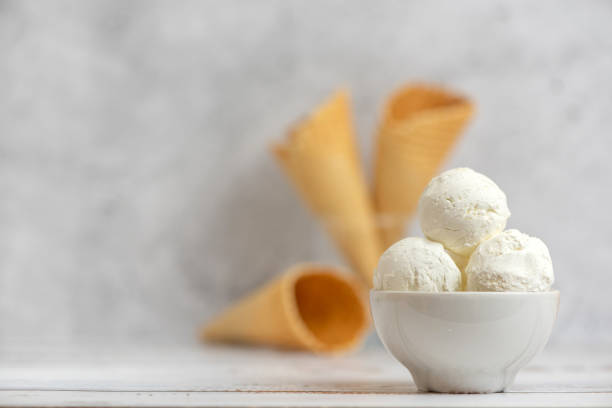 istock Bowl of vanilla ice cream and waffle cones on light background. Side view. With copy space 1131361558