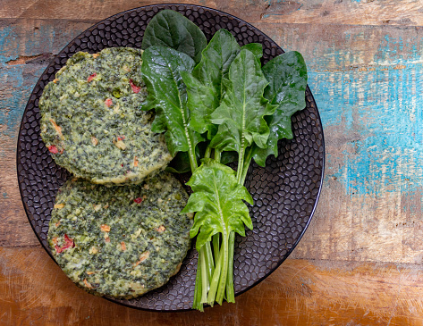 Healthy vegetarian or vegan food, uncooked green spinach burgers, ingredient for hamburgers close up