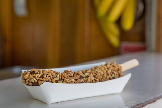 A ready to eat chocolate and nut covered frozen banana