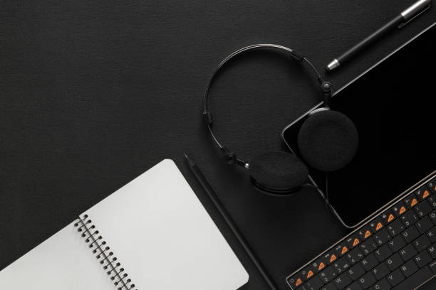 istock tablet with headphones near the keyboard on dark back 1131366854