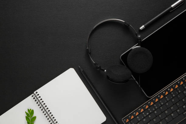 istock tablet with headphones near the keyboard on dark back 1131366946