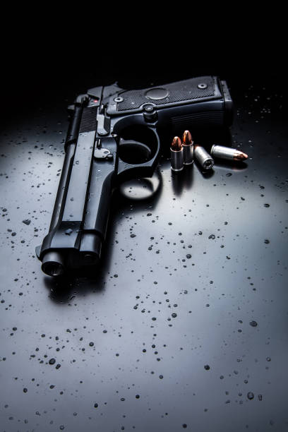 istock black modern gun on black back. 9mm pistol gun on black 1131367973
