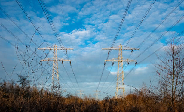 istock Electrical wires against a blue sky with clouds 1131368389
