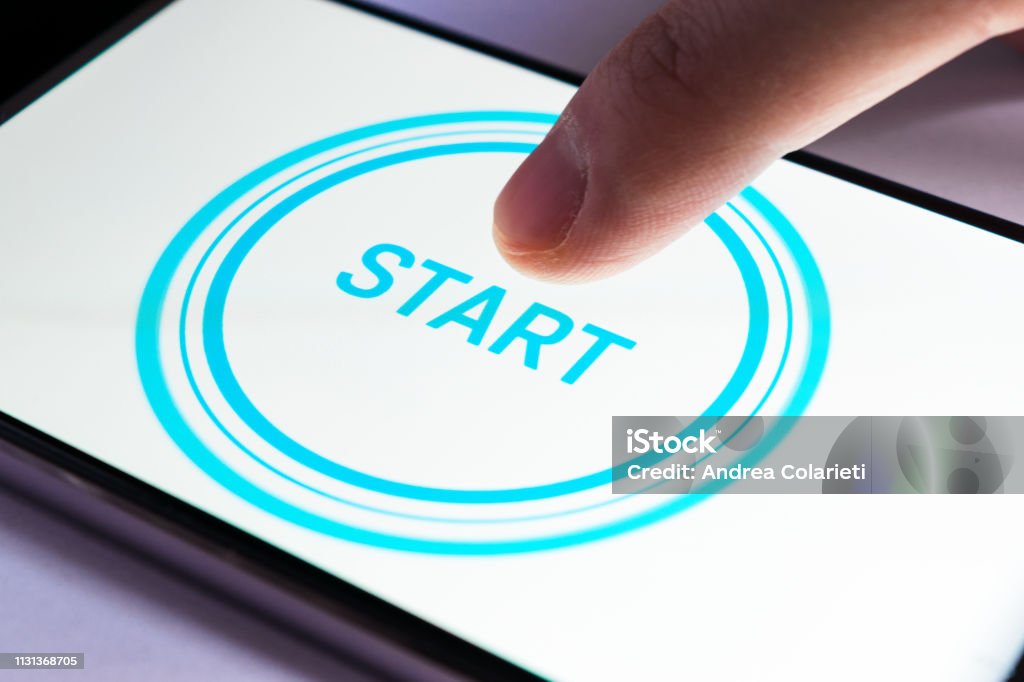 A finger clicks on the start icon on a smartphone screen Start Button Stock Photo