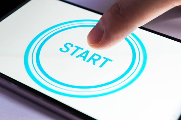 A finger clicks on the start icon on a smartphone screen stock photo