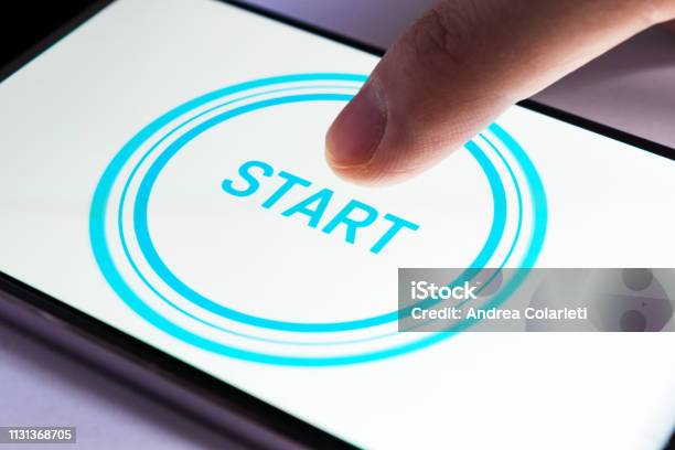 A Finger Clicks On The Start Icon On A Smartphone Screen Stock Photo - Download Image Now