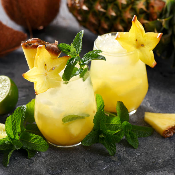 istock Cold tropical cocktail with crushed ice, carambola, pineapple, lime and mint, coconut, square image 1131368895