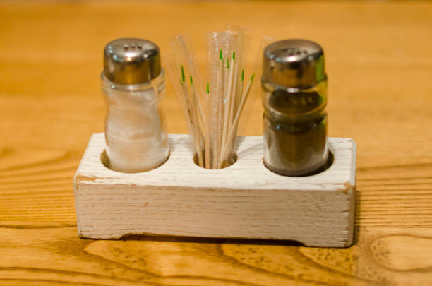 A set of salt paper and toothpicks on the wooden table background close up view. Restaurant service.