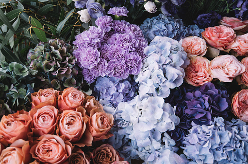 Hermosas flores florecillas (rosas, hortensias, claveles, Eustoma) en colores Blu, azul antiguo y melocotón en la floristería photo