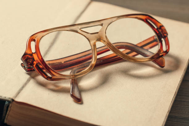 istock old book open on a wooden table with glasses 1131374173