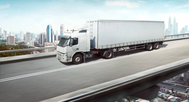 istock Truck with container on high speed overpass with city skyline 1131378512