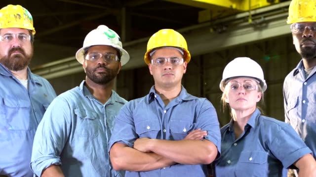 Team of workers with hard hats, safety glasses, serious