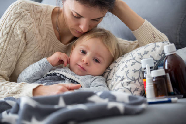 enfant malade, garçon de bambin se trouvant dans le bâti avec une fièvre, se reposant à la maison - domestic life sadness family bed photos et images de collection