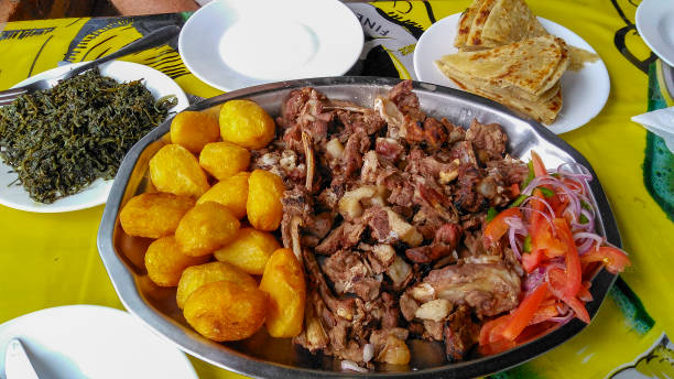 bandeja de partilha de um prato tradicional de kenyan, choma de nyama e acompanhamentos da salada de kachumbari, wiki de sukuma, chapati e batatas do assado. - accompaniments - fotografias e filmes do acervo