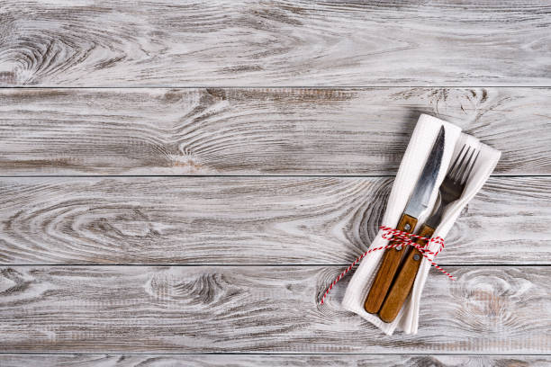 istock Empty wooden table background and fork and knife on napkin. Dinner, lunch or breackfast concept. 1131384252