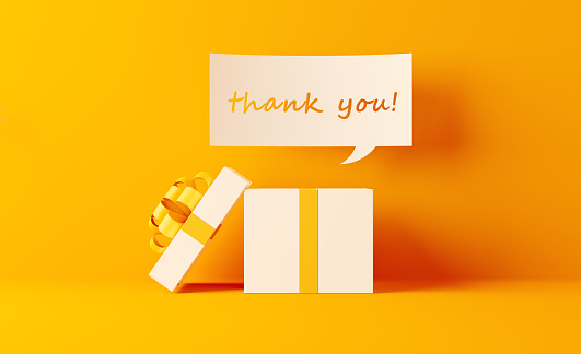 A thank you note coming out of white gift box on yellow background. Horizontal composition with  copy space. Shopping and gift concept.