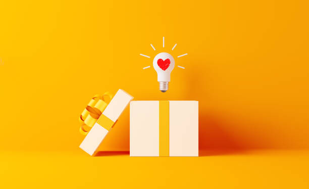 шоппинг и подарок концепция-лампочка с формой сердца выходит из белого подарочная коробка - yellow box стоковые фото и изображения