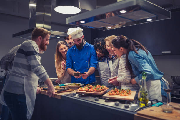 istock Chef and attendees of cooking class browsing photos on mobile phone 1131385781