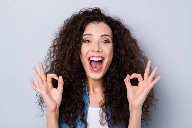 Close-up portrait of her she nice cute attractive lovely charming cheerful cheery optimistic wavy-haired girl showing two double ok-sign isolated over gray pastel background.