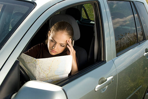 Donna con mappa in auto. - foto stock