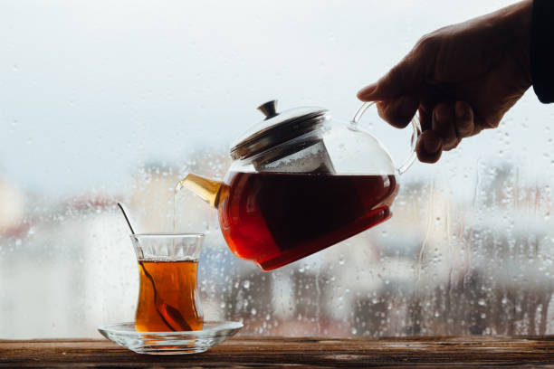 Senior men pouring tea beside window
