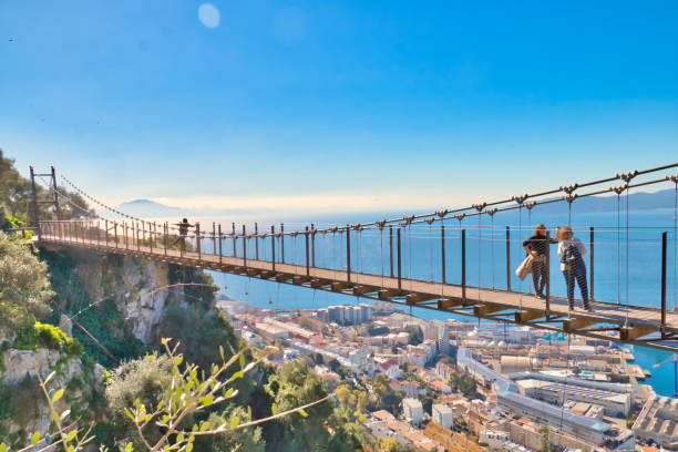 Tourists in Gibraltar crossing the Windsor suspension bridge, from where you can enjoy awesome views Gibraltar, Gibraltar - February 9, 2019: Tourists in Gibraltar crossing the Windsor suspension bridge, from where you can enjoy awesome views colony territory photos stock pictures, royalty-free photos & images