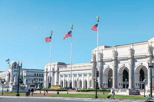 Washington DC, USA - October 12, 2018: Union Station and Columbus Circle street with three flagpoles with American flags and entrance exterior facade