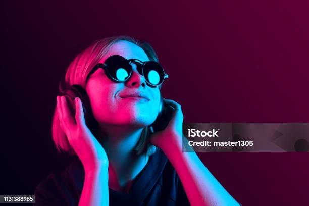 Fashion Pretty Woman With Headphones Listening To Music Over Neon Background Stock Photo - Download Image Now