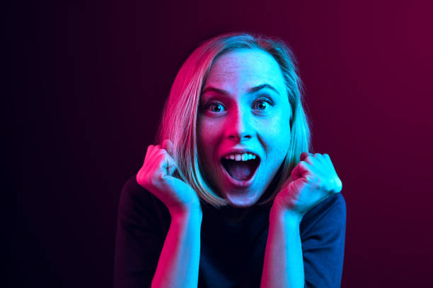 istock Beautiful woman looking suprised isolated on neon 1131388994