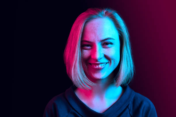 wanita bisnis yang bahagia berdiri dan tersenyum dengan latar belakang neon. - lilin-peralatan-penerangan potret stok, foto, & gambar bebas royalti