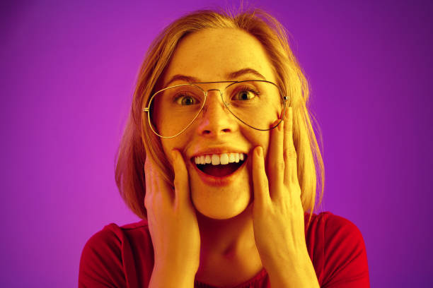 istock Beautiful woman looking suprised isolated on neon background 1131389036