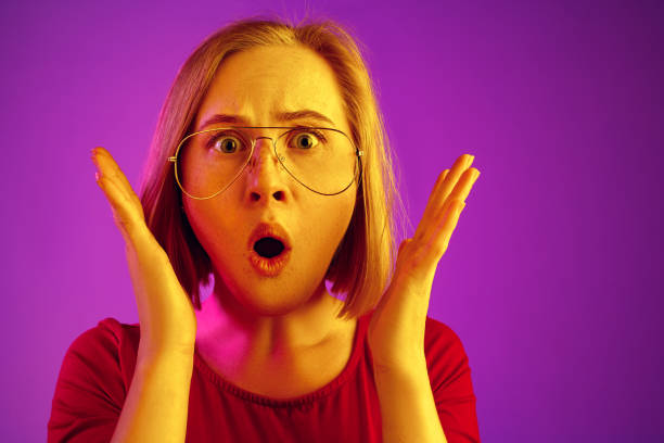 istock Beautiful woman looking suprised isolated on neon 1131389043