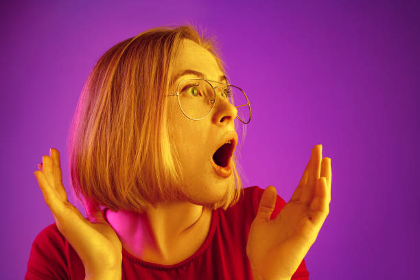 istock Beautiful woman looking suprised isolated on neon 1131389066