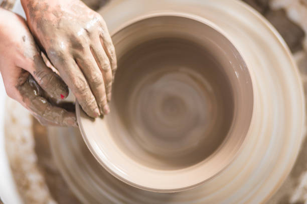 istock Close - up female hands making pottery on a pottery wheel in the art studio 1131391178