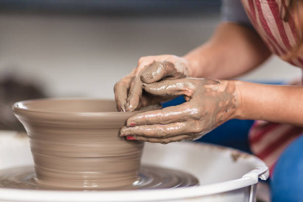 istock Close - up female hands making pottery on a pottery wheel in the art studio 1131391179