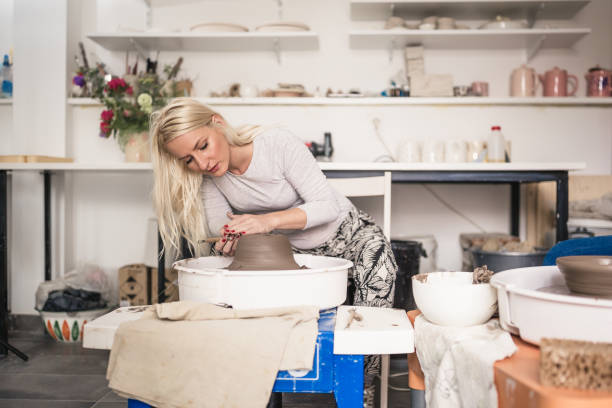 istock Young women making pottery on a pottery wheel in the art studio. 1131391240