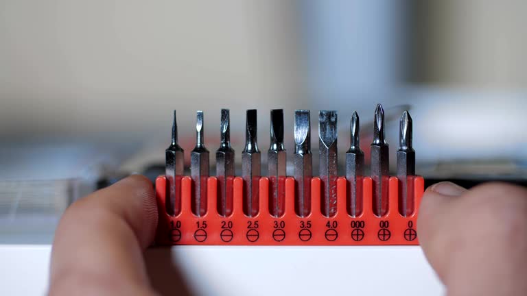 Extreme Close-Up of Instruments. Dolly Shot of a Screwdriver Bit Set, Hands Preparing for Work, Red Color, Toolbox set