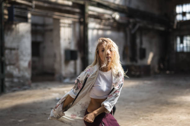 Female break dancer exercises in old storage