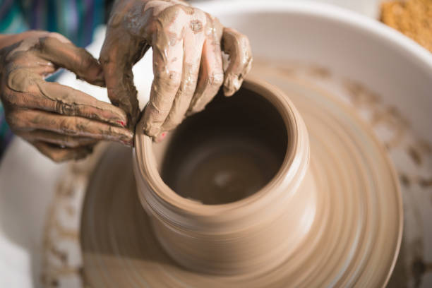 istock Close - up female hands making pottery on a pottery wheel in the art studio 1131392226