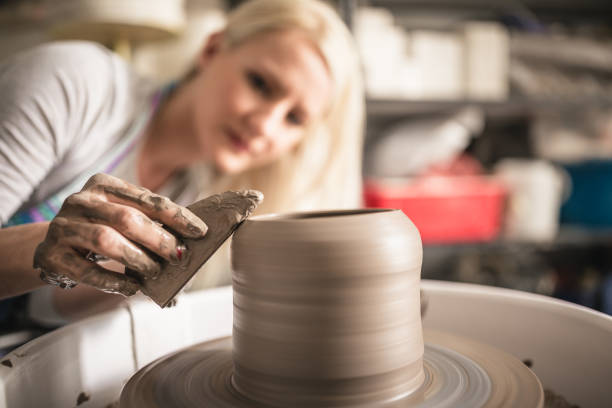 istock Young women, making pottery on a pottery wheel in the art studio. 1131392277