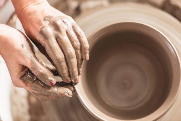 istock Close - up female hands making pottery on a pottery wheel in the art studio 1131392364