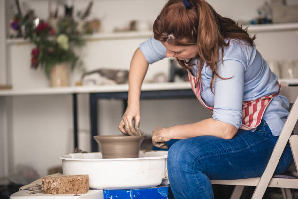 istock Young women making pottery on a pottery wheel in the art studio. 1131392417