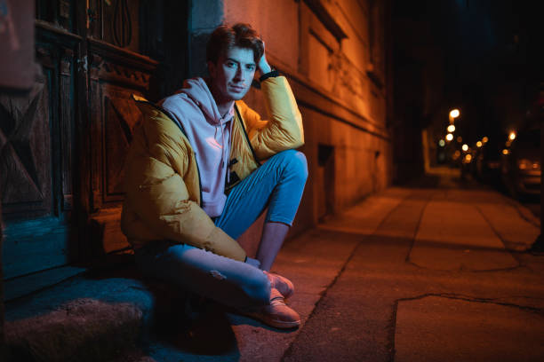 Beautiful and handsome hipster sitting on the city street.