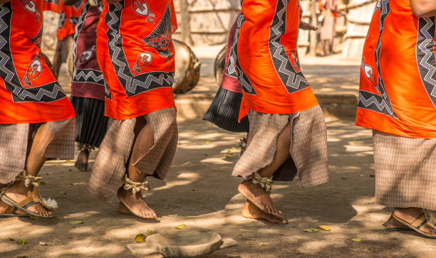 tradycyjni afrykańscy tancerze na sandałach tańczą na świeżym powietrzu w kolorowych ubraniach. - african dance zdjęcia i obrazy z banku zdjęć
