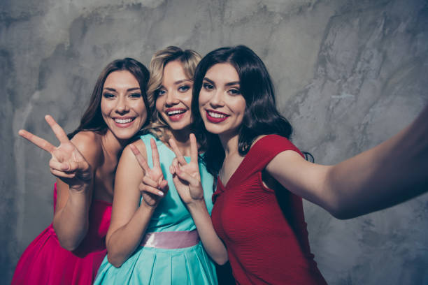self-portrait of three nice-looking lovely chic elegant attractive glamorous cheerful cheery ladies in maroon burgundy mint pink clothes showing v-sign over gray concrete wall - bachelorette party imagens e fotografias de stock
