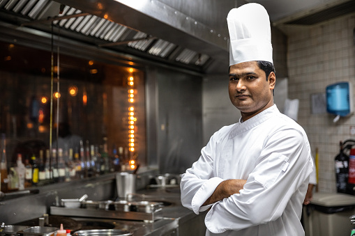 Indian chefs cooking in a professional kitchen of a gourmet restaurant.